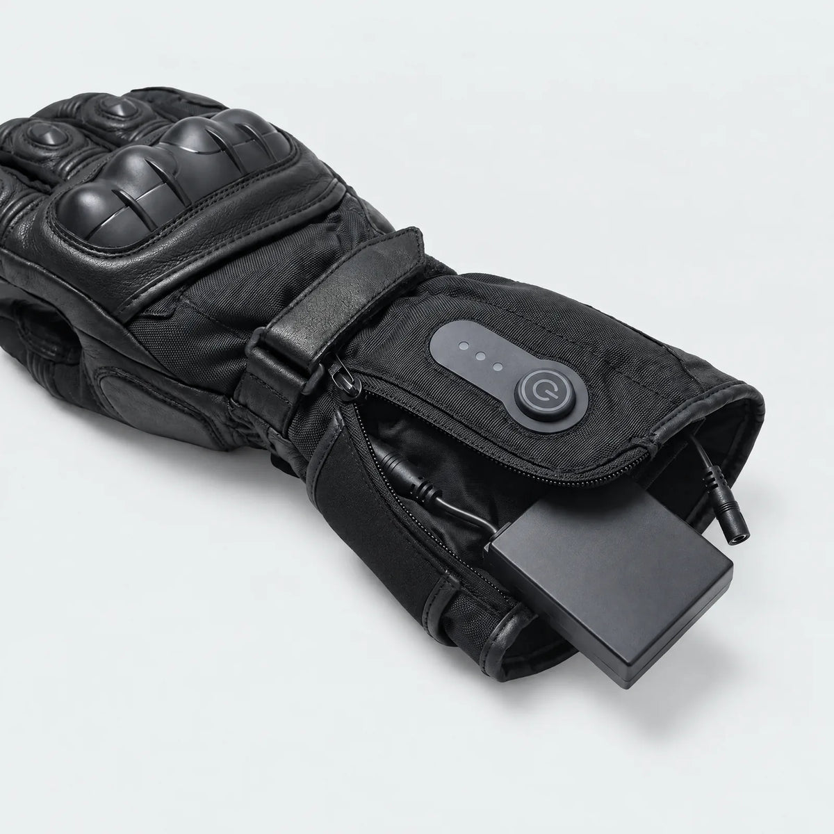 Battery pocket in the gauntlet of the heated motorcycle gloves, with button and light indicator