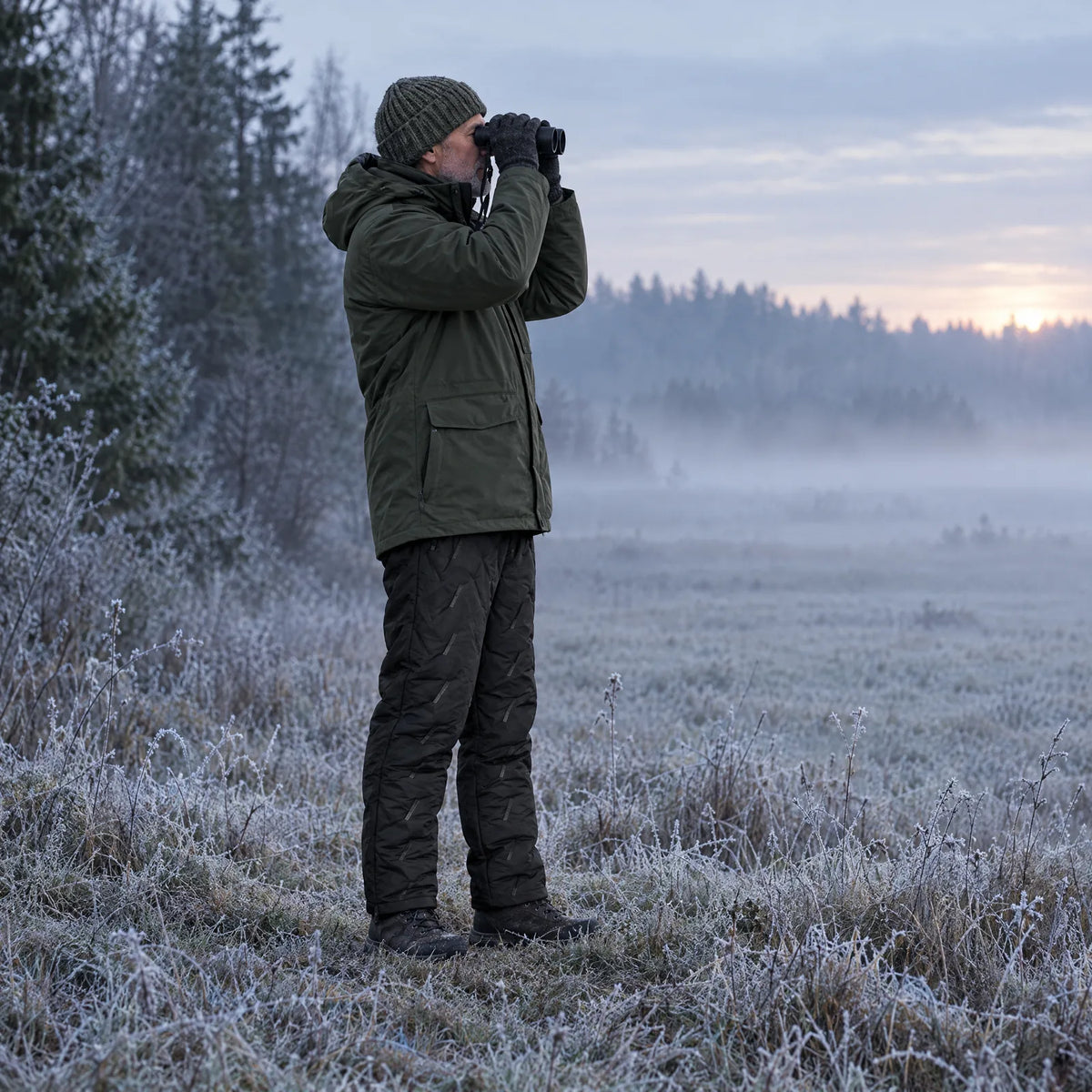 Bird watching on a frosty meadow in the heated winter pants