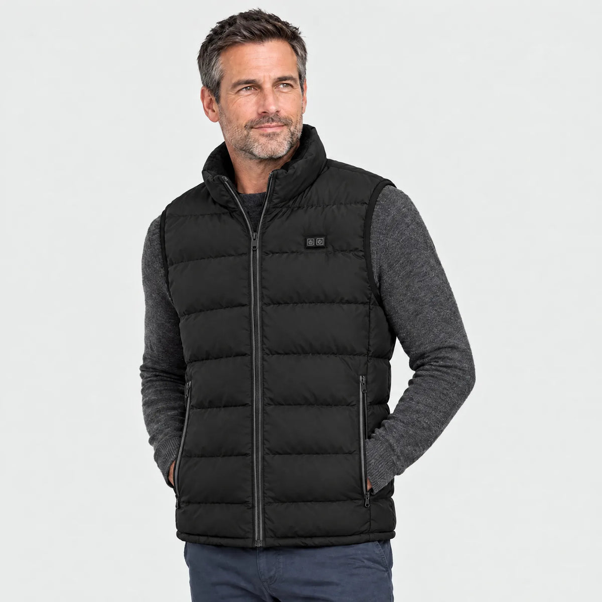 Man wearing the black heated vest over a grey sweater, front view